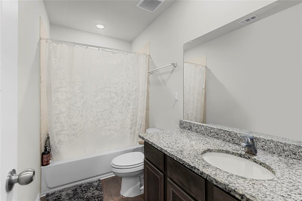 401 Thompson Place Everman, TX 76140 - Photo 20 of 23 a bathroom with a granite countertop sink toilet and shower