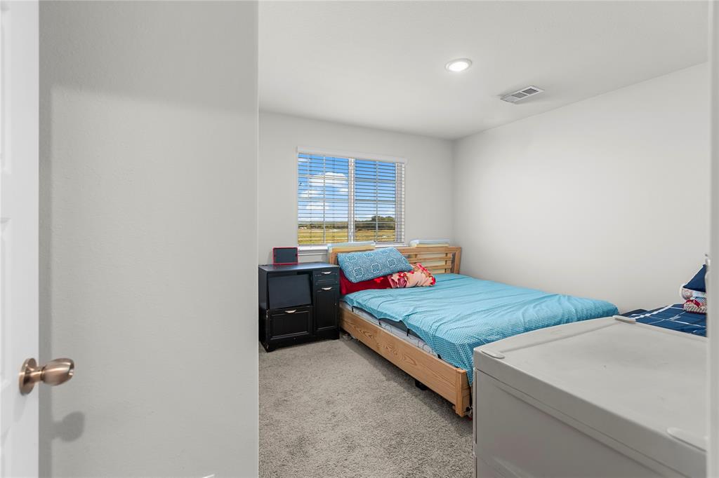 401 Thompson Place Everman, TX 76140 - Photo 21 of 23 a bed room with a bed and two windows