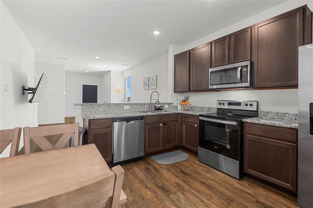 401 Thompson Place Everman, TX 76140 - Photo 10 of 23 a kitchen with stainless steel appliances granite countertop a stove sink microwave and cabinets