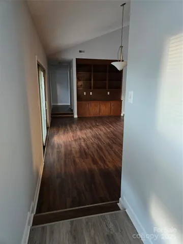 a view of a small space with wooden floor and cabinet