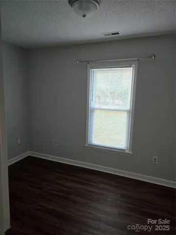 an empty room with wooden floor and a window