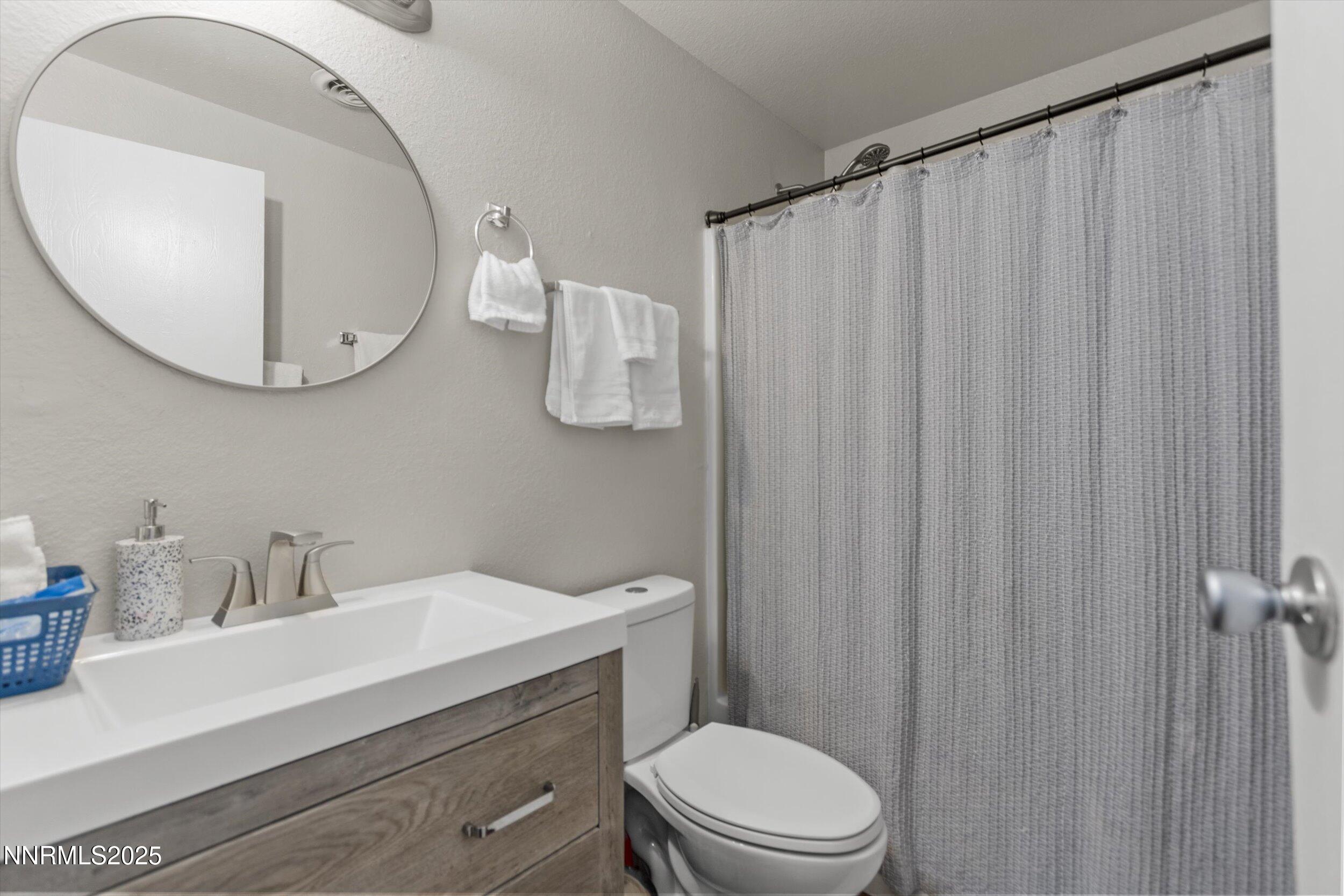 400 Claremont Street Reno, NV 89502 - Photo 7 of 32 a bathroom with a sink a toilet a mirror and vanity
