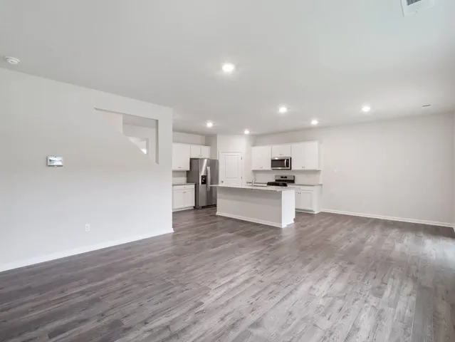 a view of kitchen with kitchen island wooden floor and center island