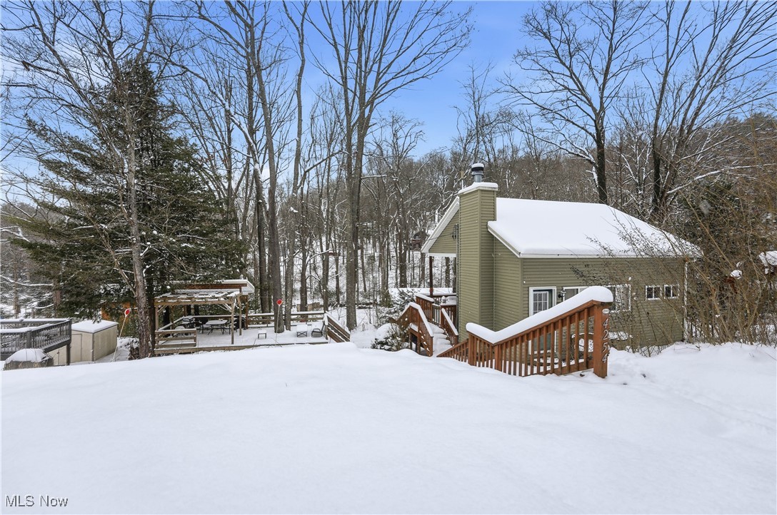 4254 Doral Road Southwest Carrollton, OH 44615 - Photo 44 of 46 Yard layered in snow featuring a deck, a gazebo, and view of wooded area