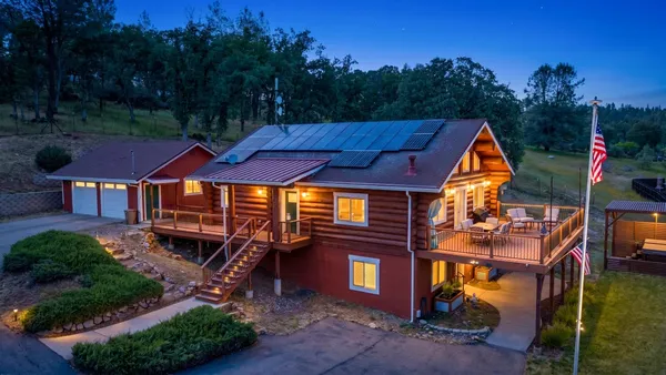 an aerial view of a house with swimming pool and sitting area