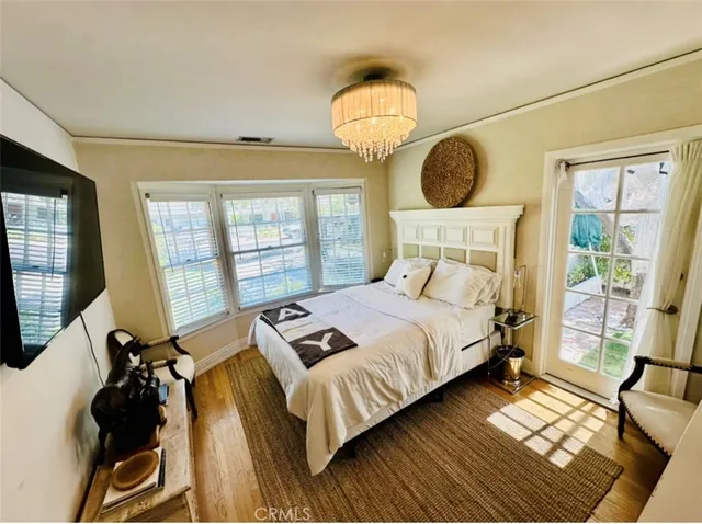 a bedroom with bed mirror and window