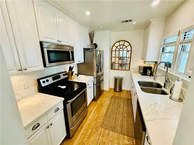 a kitchen with stainless steel appliances a stove microwave and sink