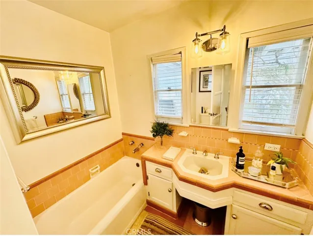 a bathroom with a tub sink and mirror