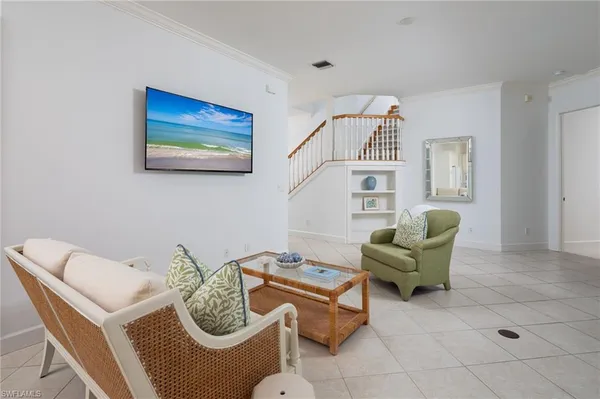 a living room with furniture and a white wall next to a window