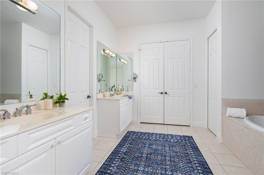 155 1st Avenue South Naples, FL 34102 - Photo 18 of 27 a bathroom with a sink a toilet and a mirror