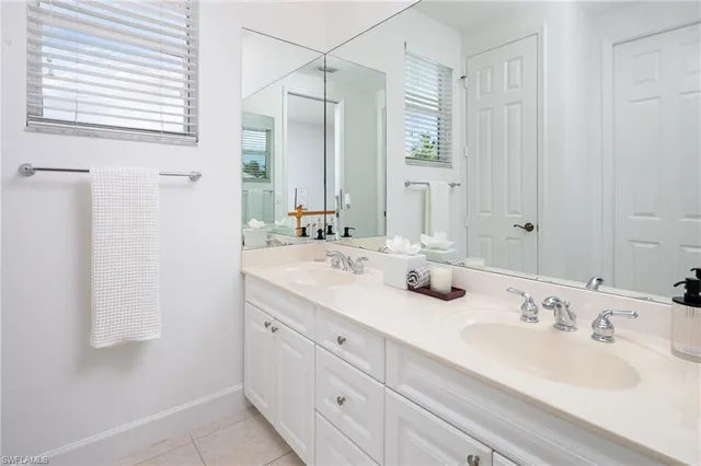 a bathroom with double sink and a mirror