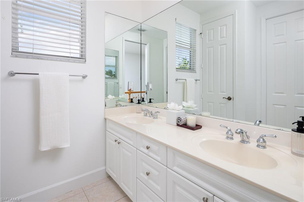 155 1st Avenue South Naples, FL 34102 - Photo 23 of 27 a bathroom with double sink and a mirror