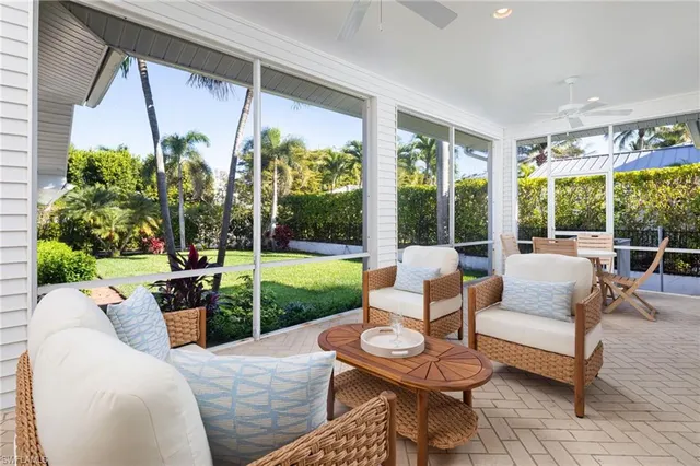 a living room with patio furniture and a garden
