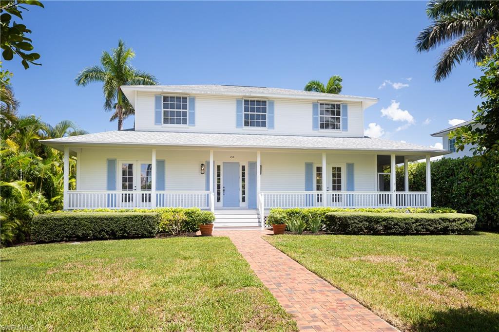 155 1st Avenue South Naples, FL 34102 - Photo 5 of 27 a front view of a house with a yard and potted plants