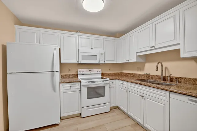 a kitchen with cabinets appliances a sink and a counter space