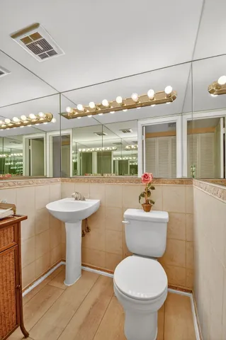 a bathroom with a toilet sink and mirror