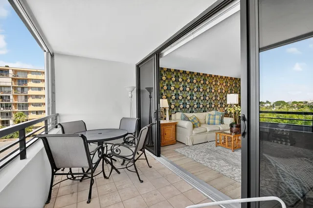 a dining room with furniture and a floor to ceiling window