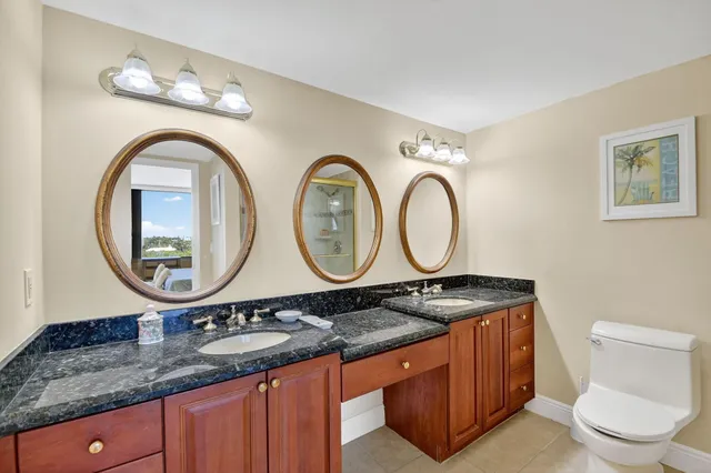 a bathroom with a granite countertop double vanity sink and a mirror