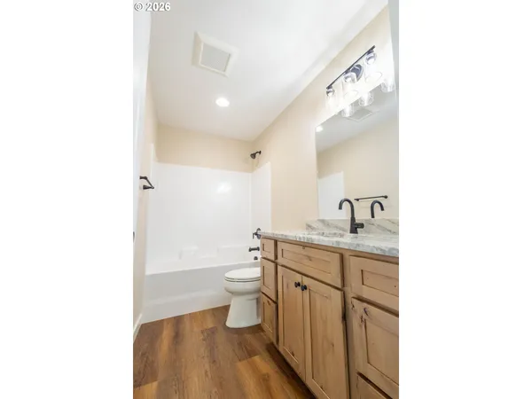 a bathroom with a granite countertop toilet a sink and a mirror