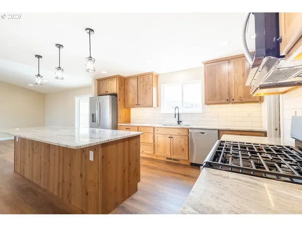 a kitchen with kitchen island granite countertop a sink and a stove