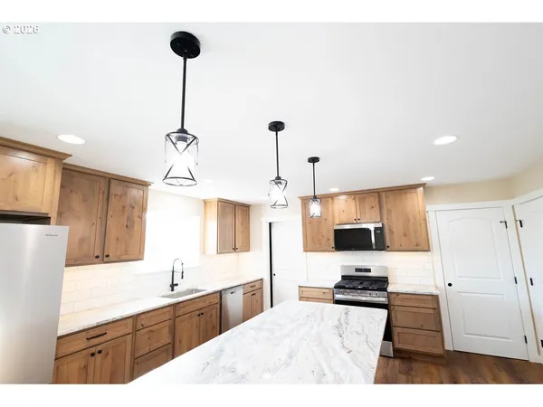 a large kitchen with kitchen island a sink stainless steel appliances and cabinets