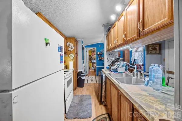 a kitchen with stainless steel appliances granite countertop a refrigerator a stove and a sink with wooden floor