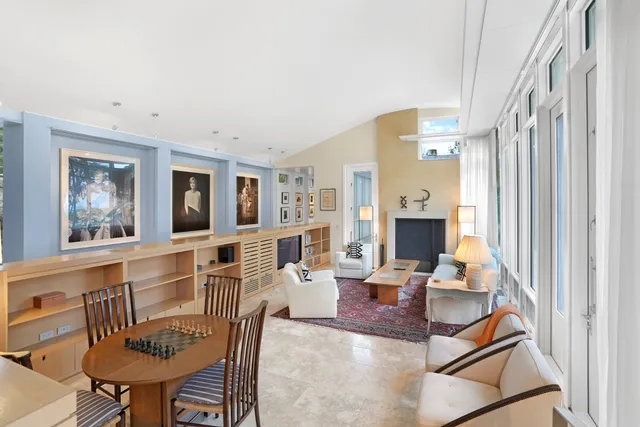 a living room with fireplace furniture and a large window