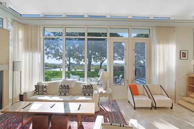 a dining room with furniture and a floor to ceiling window
