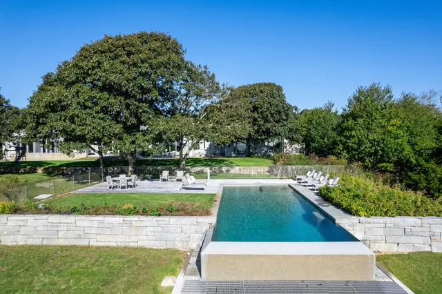 a view of yard with swimming pool and trees in the background
