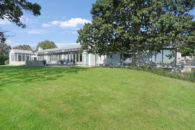 a view of a house with a big yard and large trees
