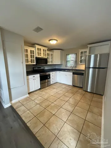 a kitchen with stainless steel appliances a refrigerator and a stove top oven