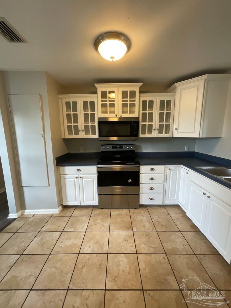 809 West Government Street Pensacola, FL 32502 - Photo 5 of 15 a kitchen with stainless steel appliances granite countertop a stove a sink and a microwave
