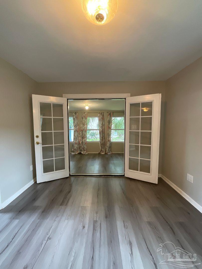 809 West Government Street Pensacola, FL 32502 - Photo 8 of 15 an empty room with wooden floor and windows