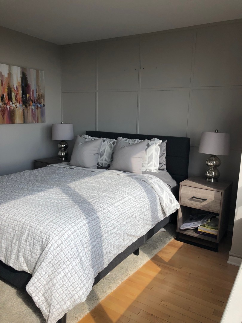 3930 North Pine Grove Avenue, Unit 1606 Chicago, IL 60613 - Photo 12 of 17 a bed room with a bed and a couch