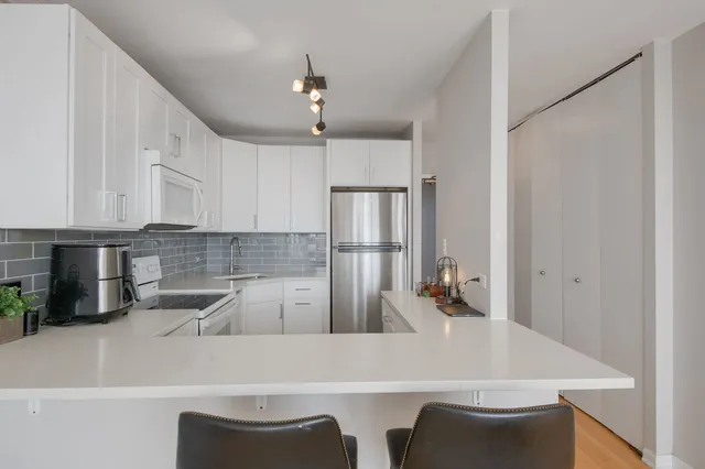 a kitchen with a table chairs microwave and cabinets