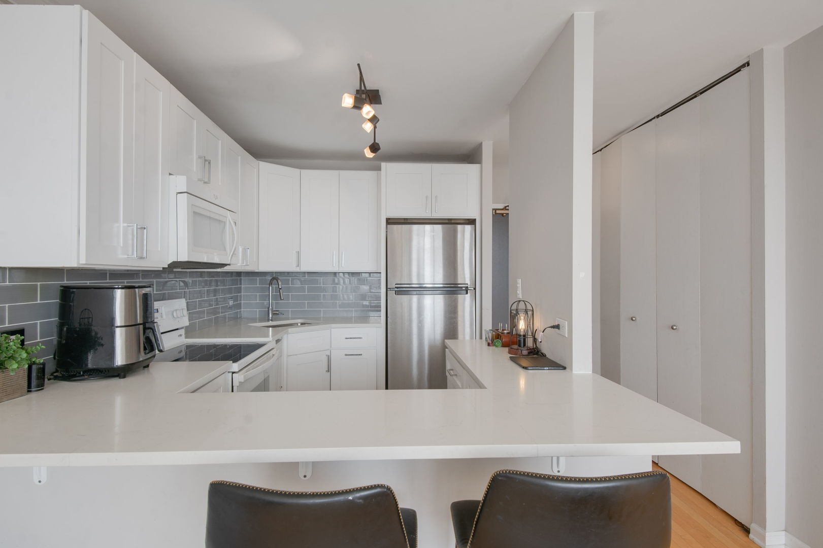 3930 North Pine Grove Avenue, Unit 1606 Chicago, IL 60613 - Photo 3 of 17 a kitchen with a table chairs microwave and cabinets