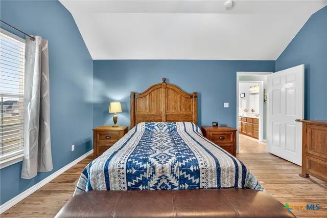 a bedroom with a bed and dresser with mirror