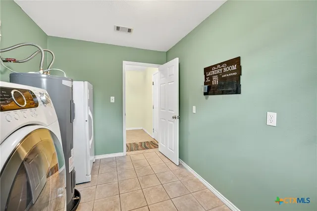 a patio with table and chairs and potted plants