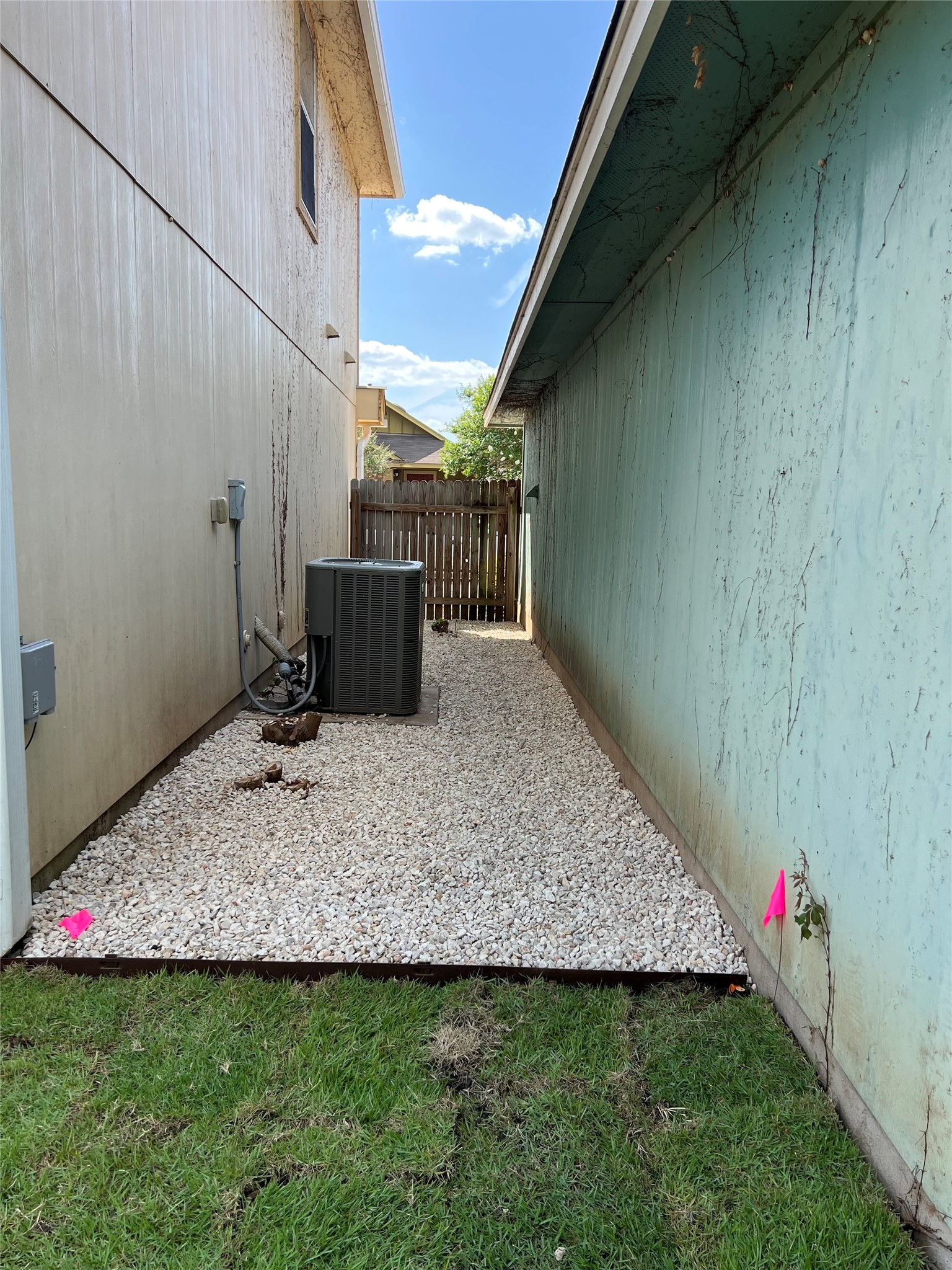 4625 Credo Lane Austin, TX 78725 - Photo 29 of 34 Gravel pathway lines the side yard between structures leading to a wooden fence.