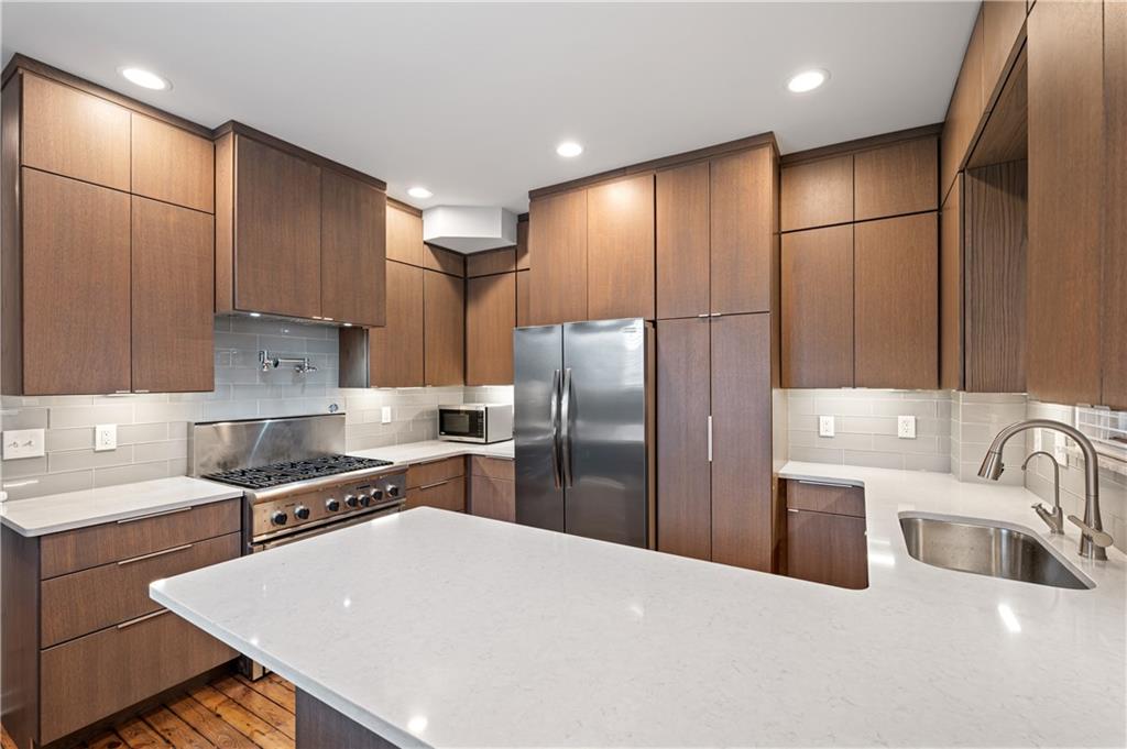 4808 Lima Way Pittsburgh, PA 15224 - Photo 6 of 26 a kitchen with stainless steel appliances a refrigerator a sink a stove a microwave and wooden cabinets