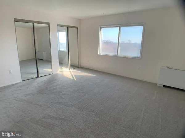 an empty room with windows and closet