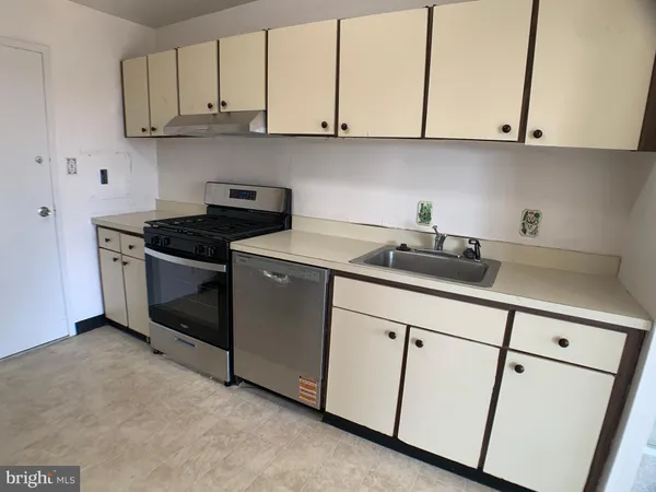 a kitchen with white cabinets and a stove