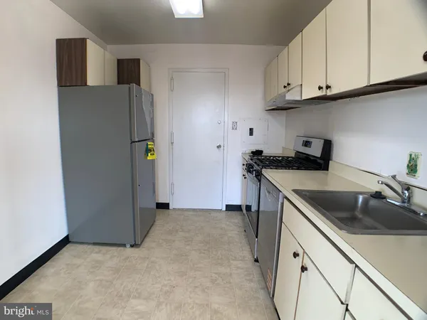 a kitchen with stainless steel appliances granite countertop a refrigerator a sink a stove and white cabinets