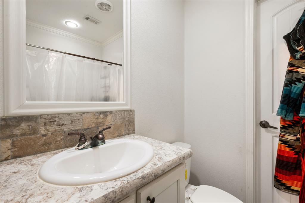 660 Deer Trail Gordon, TX 76453 - Photo 32 of 40 a bathroom with a granite countertop sink a toilet and a mirror