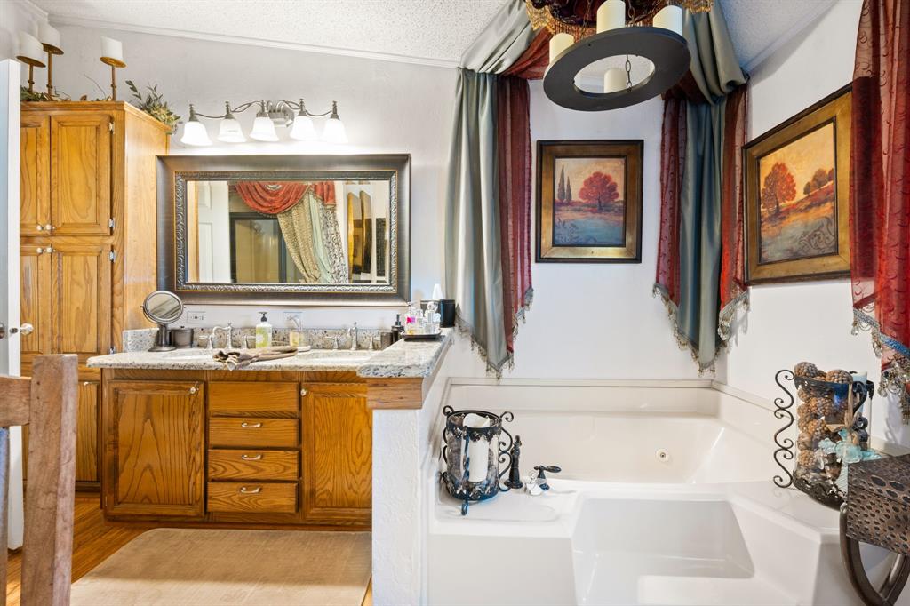 660 Deer Trail Gordon, TX 76453 - Photo 9 of 40 a bathroom with a tub sink and mirror