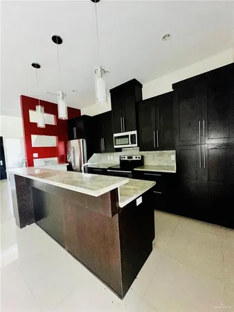 a kitchen with stainless steel appliances granite countertop a sink a stove and a refrigerator