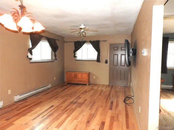 en empty room with wooden floor fan and window