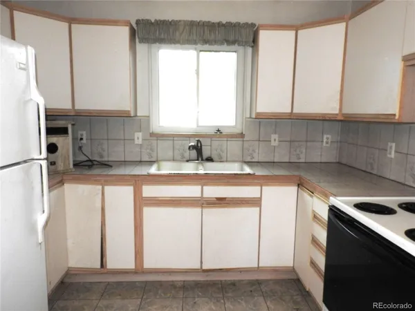 a kitchen with stainless steel appliances white cabinets and a window