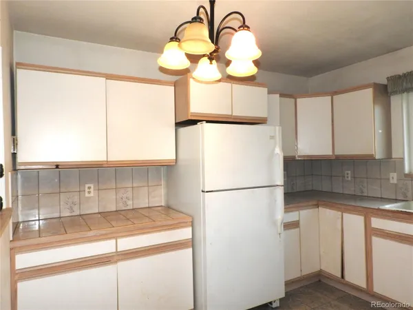 a kitchen with a refrigerator and a white sink