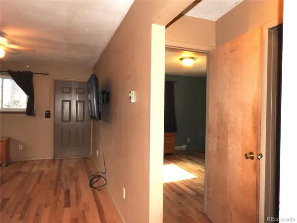 a view of a hallway with wooden floor and staircase